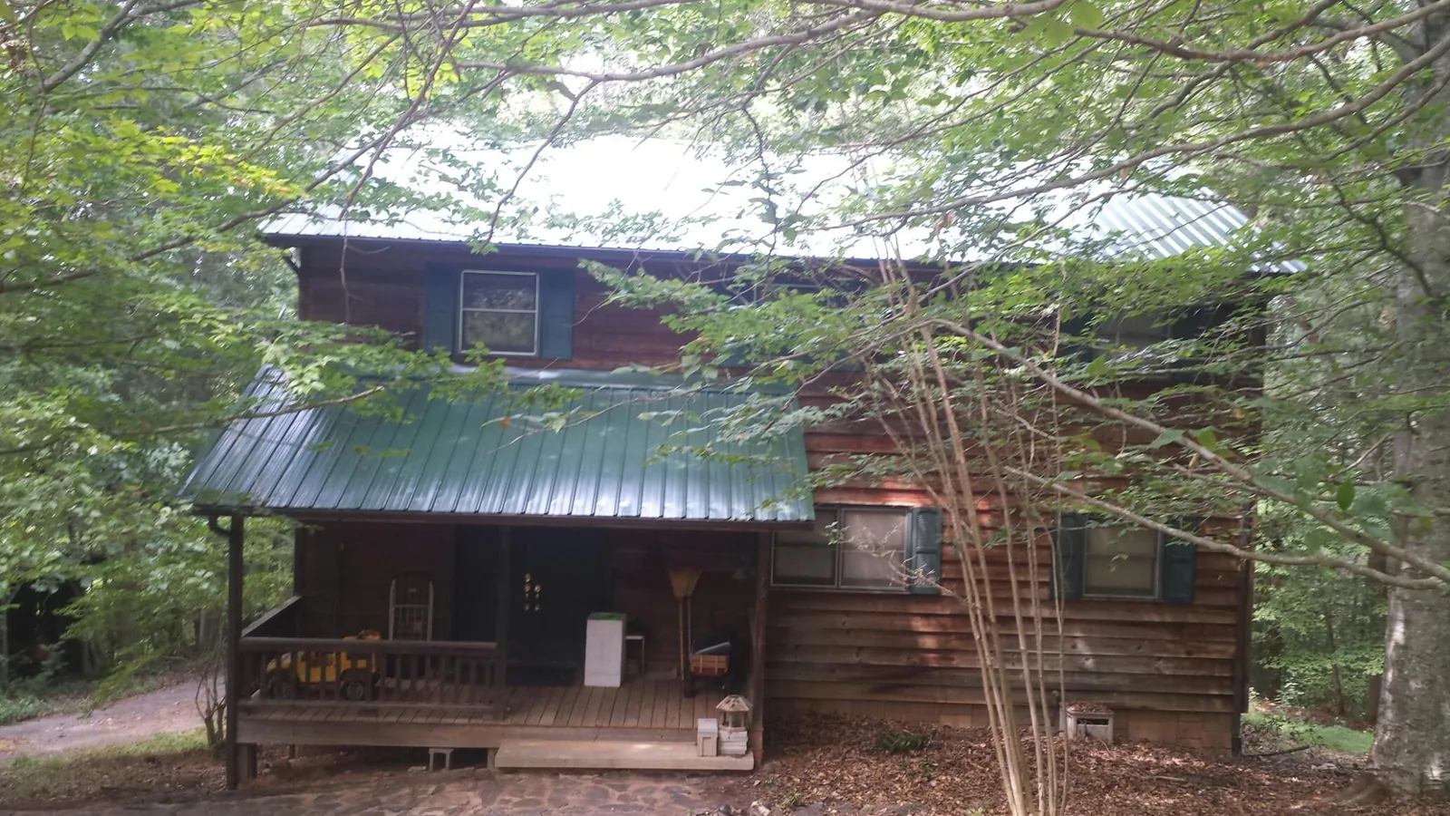 Green metal roof and covered porch on a log cabin in Nevada